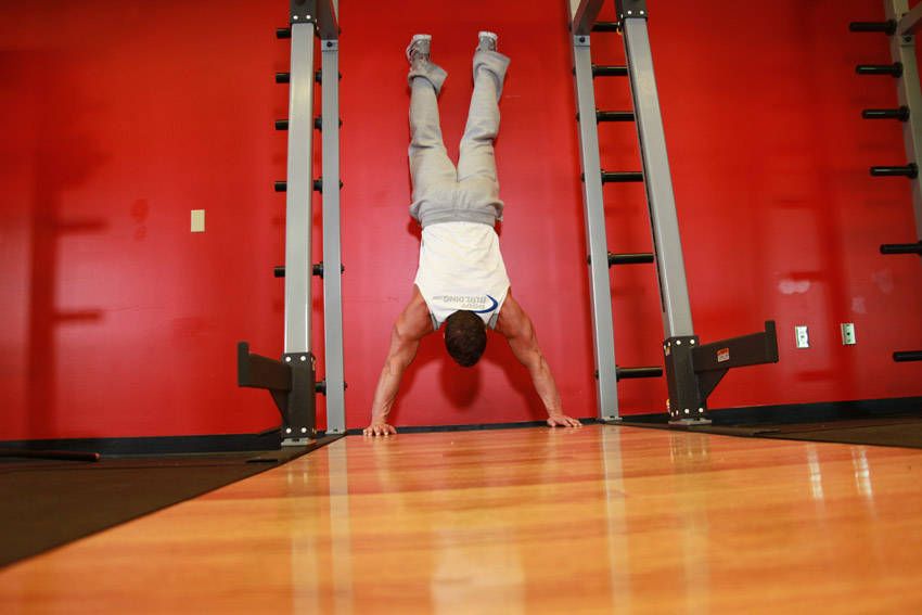 Wall Handstand Push-Up exercise demonstration, targeting the shoulders